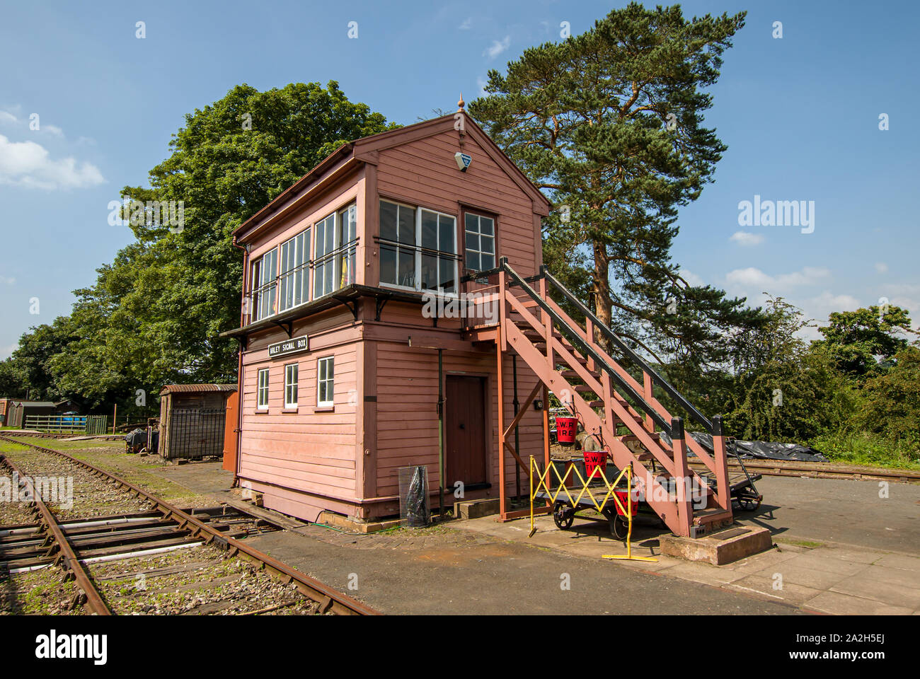 Old wooden railway signal box by the side of a railway track in Summer Stock Photo