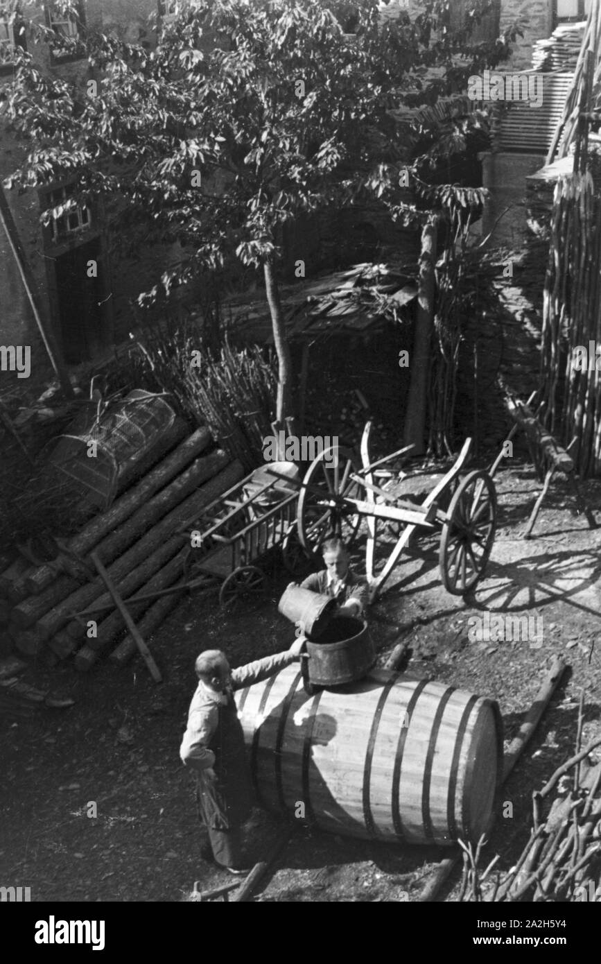 Moselbauer bei der Arbeit als Böttcher, Deutschland 1930er Jahre. Winegrower at work, producing a cask, Germany 1930s. Stock Photo
