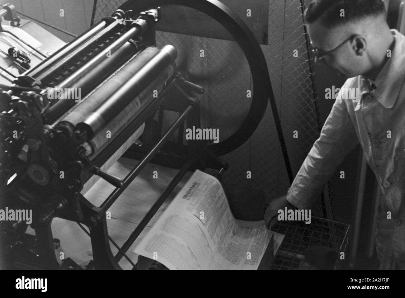 Arbeiter an einer Druckerpresse, Deutschland 1930er Jahre. Worker at a printing press, Germany 1930s. Stock Photo