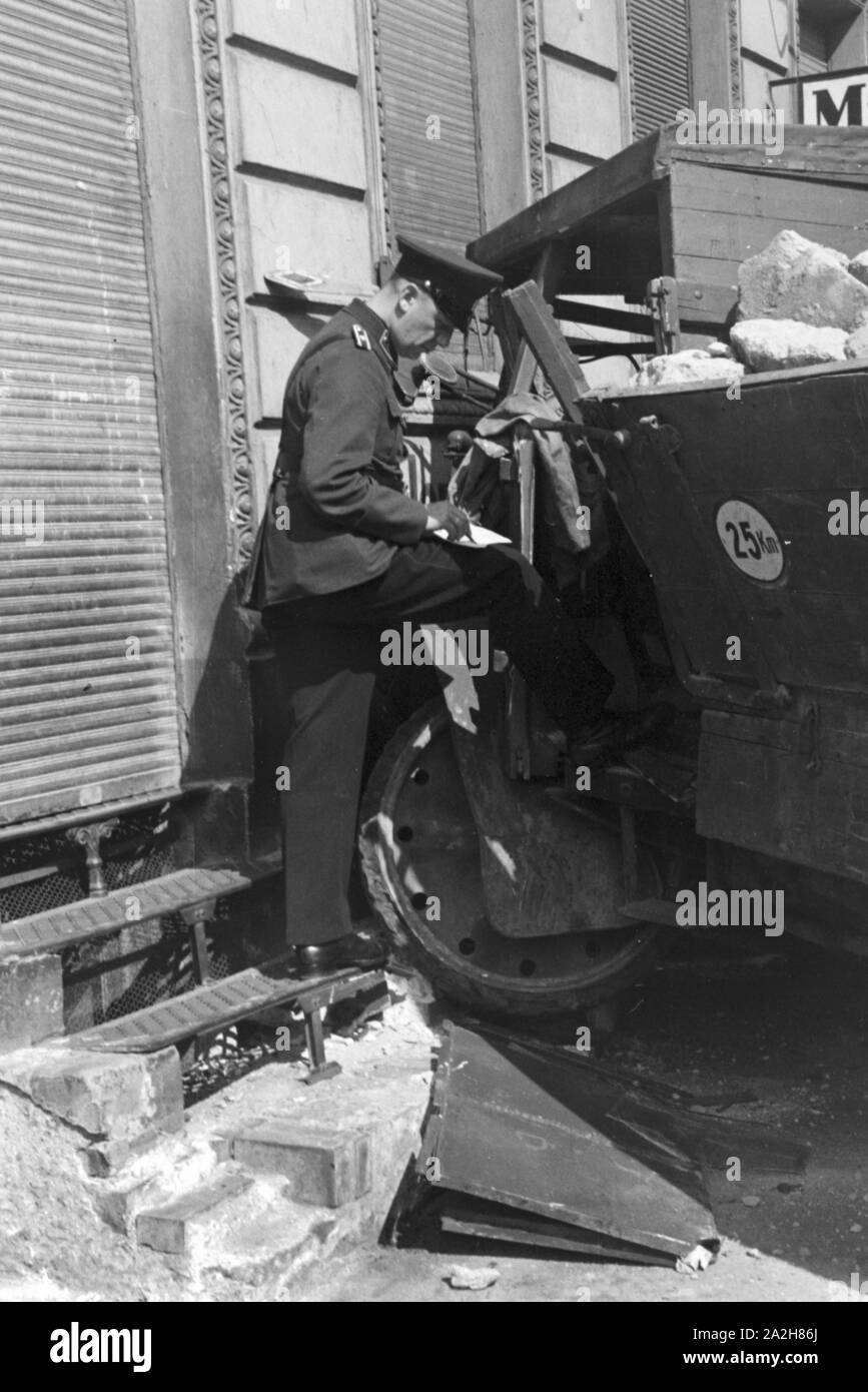 Ein Polizist bei einem Verkehrsunfall, Deutschland 1930er Jahre. A policeman at a traffic accident, Germany 1930s. Stock Photo