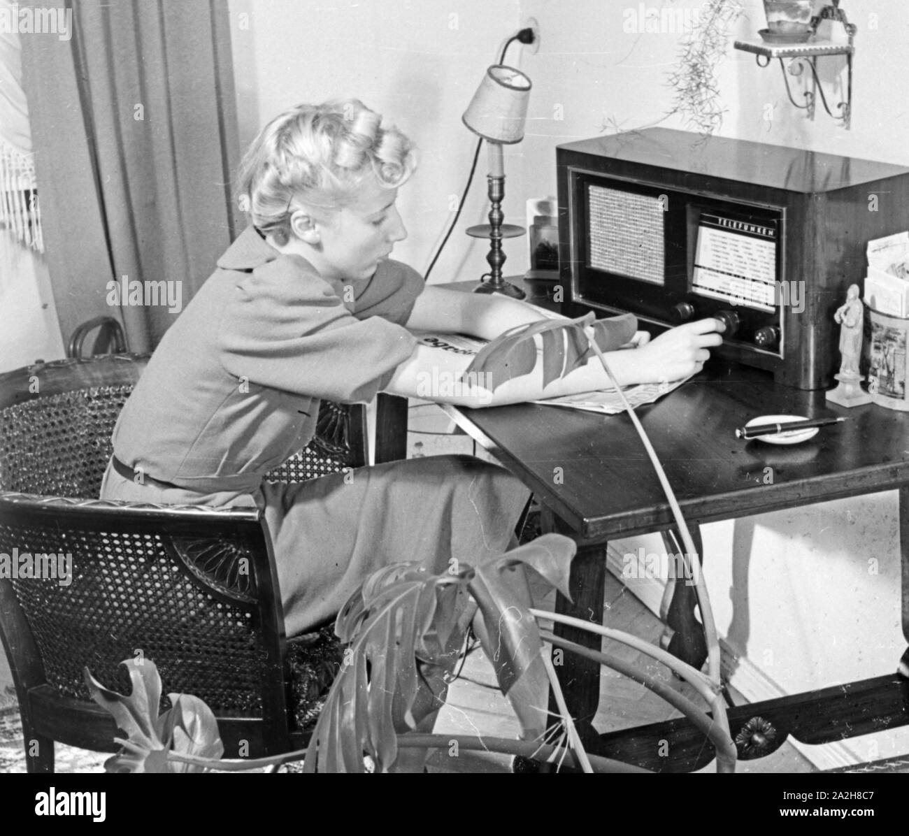 Das Radio steht auf dem Schreibtisch einer Frau, Deutschland 1930er Jahre. Radio on a desk of a woman, Germany 1930s. Stock Photo