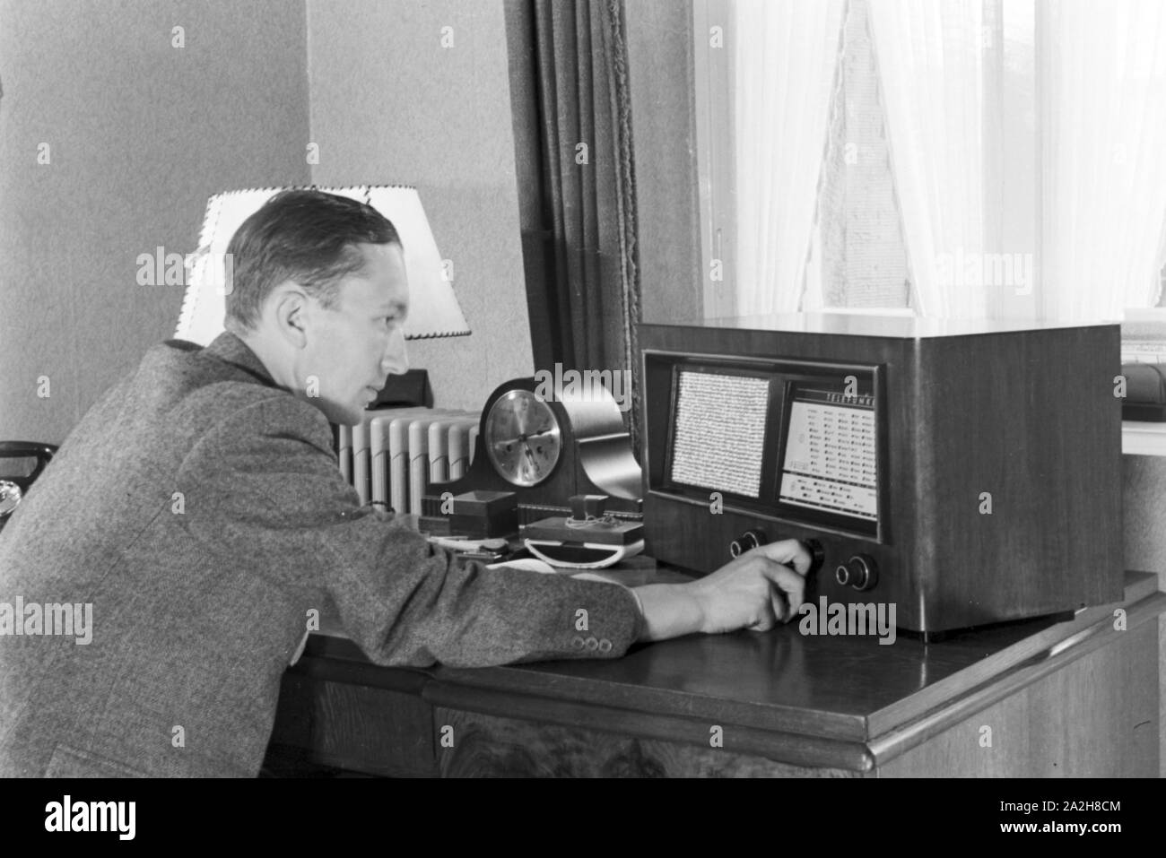 Das Radio steht auf dem Schreibtisch eines Mannes, Deutschland 1930er Jahre. Radio on a desk of a man, Germany 1930s. Stock Photo