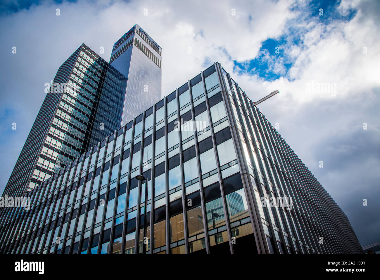 Modern Building with glass windows on a cloudy bright sky in Manchester Stock Photo