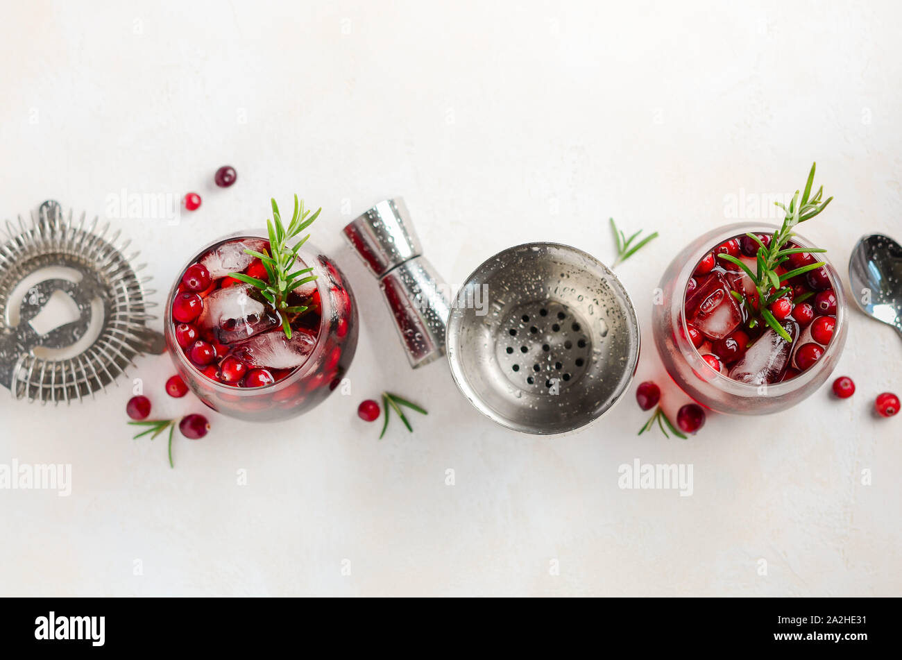 Cold refreshing drink with cranberries and rosemary on a white concrete background, top view, copy space Stock Photo