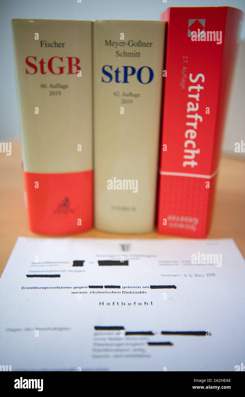Stuttgart, Germany. 02nd Oct, 2019. ILLUSTRATION - A copy of an arrest  warrant of the Nürtingen Local Court is on the table with the Criminal Code  (StGB), the Criminal Procedure Code (StPO)
