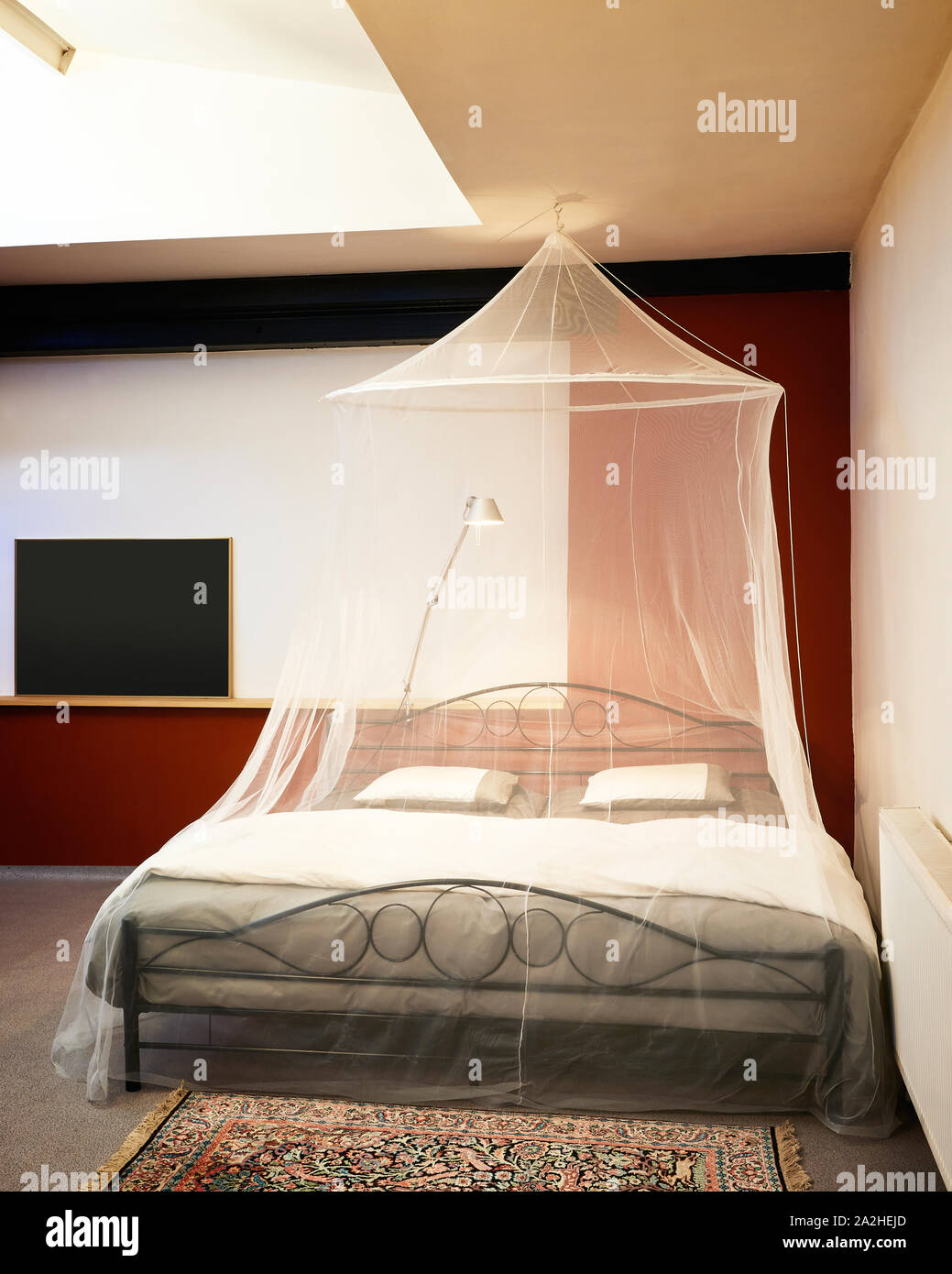 Cosi vintage bed with mosquito Net in a restored loft Stock Photo