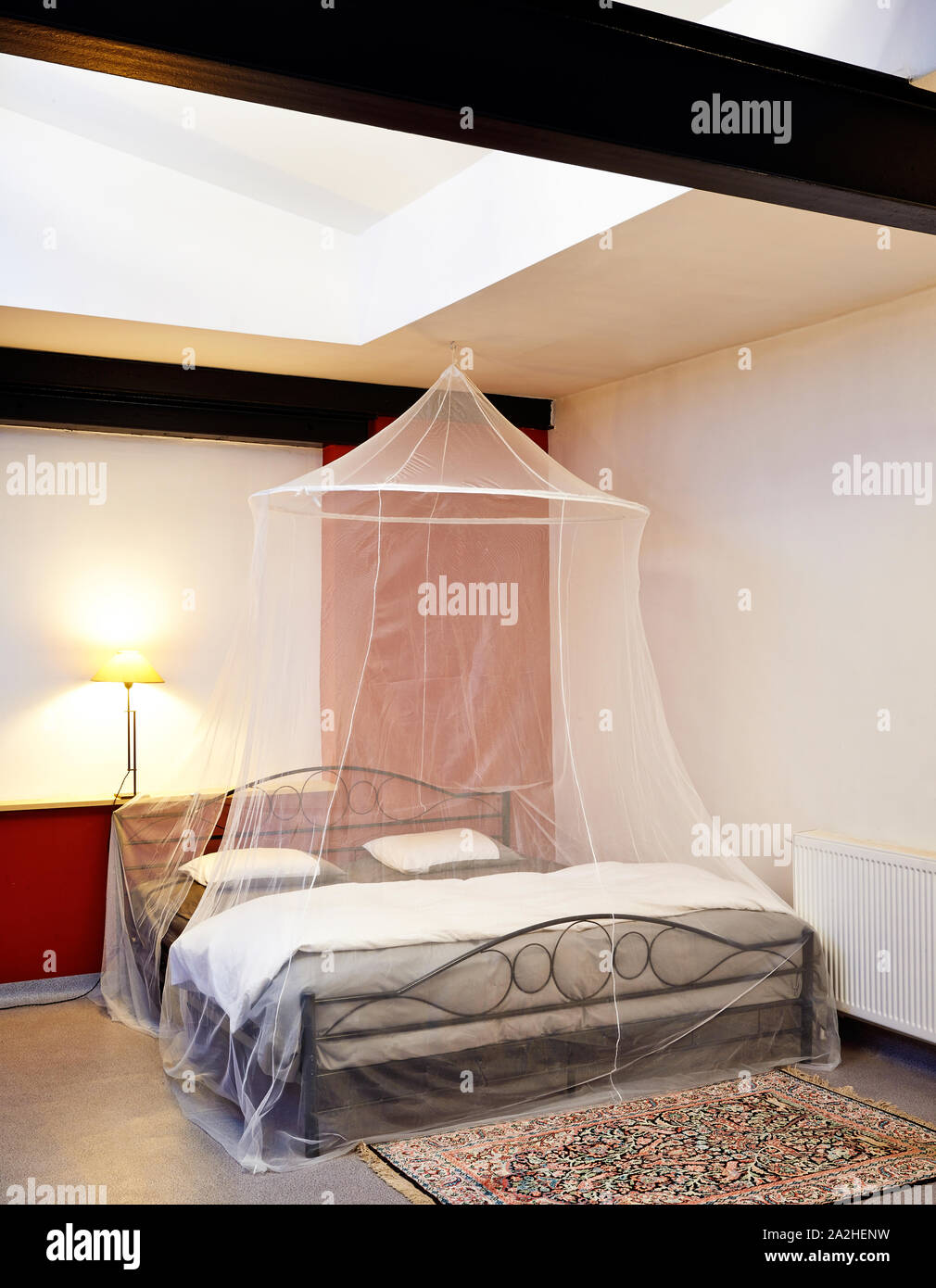 Cosi vintage bed with mosquito Net in a restored loft Stock Photo