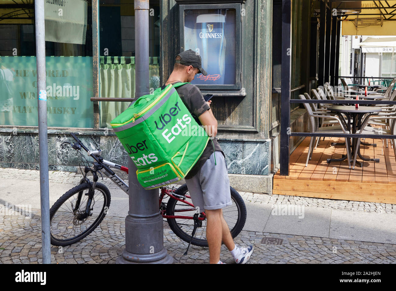 Polen Wroclaw Uber Eats driver on a bike waiting for the food looking on his mobile  8-8-2019 foto Jaco Klamer Stock Photo
