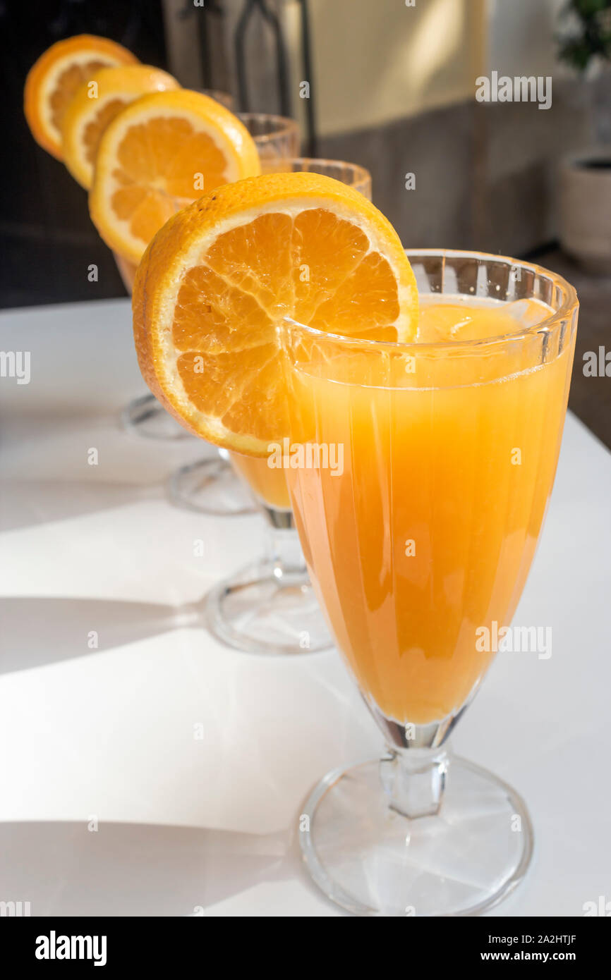 Four glasses of freshly squeezed orange juice. Stock Photo