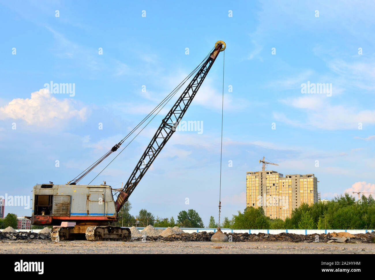 Large crawler crane or dragline excavator with a heavy metal wrecking ball on a steel cable. Wrecking balls at construction sites. Dismantling and dem Stock Photo