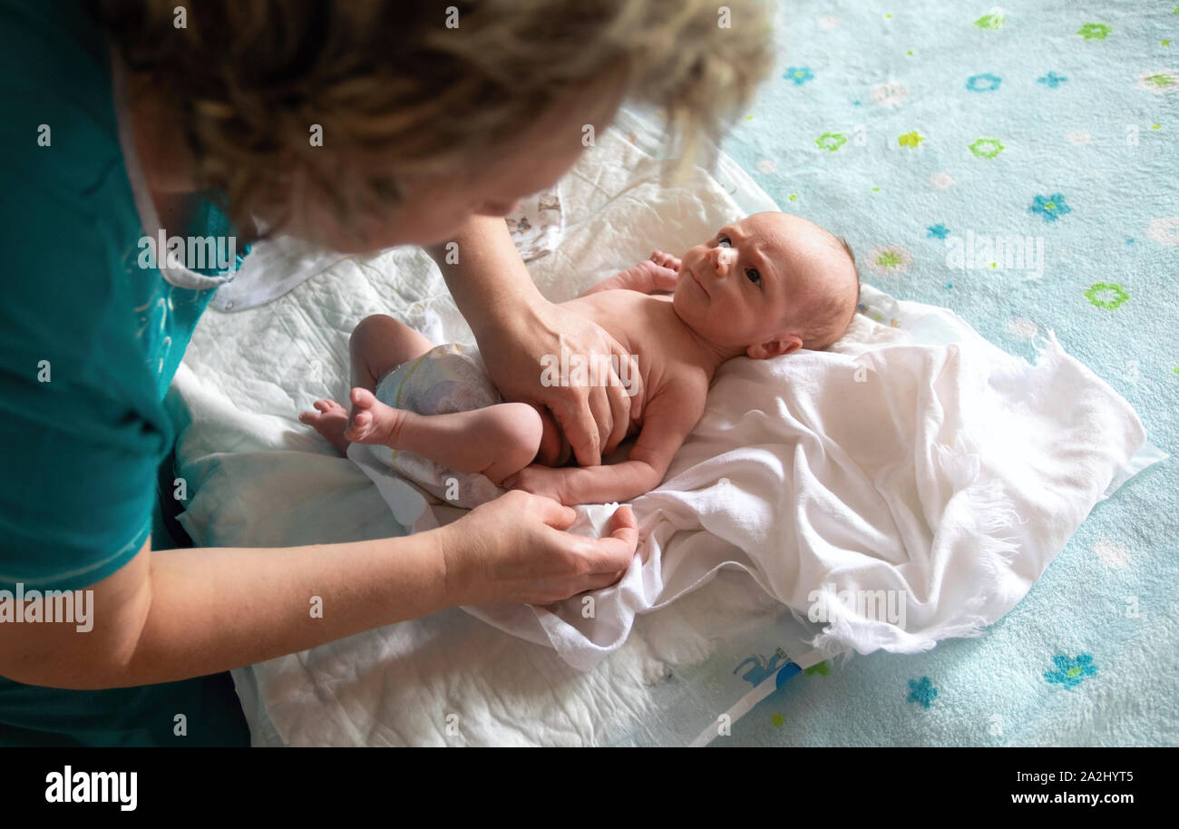 Rocking the baby in her arms at home Stock Photo Alamy