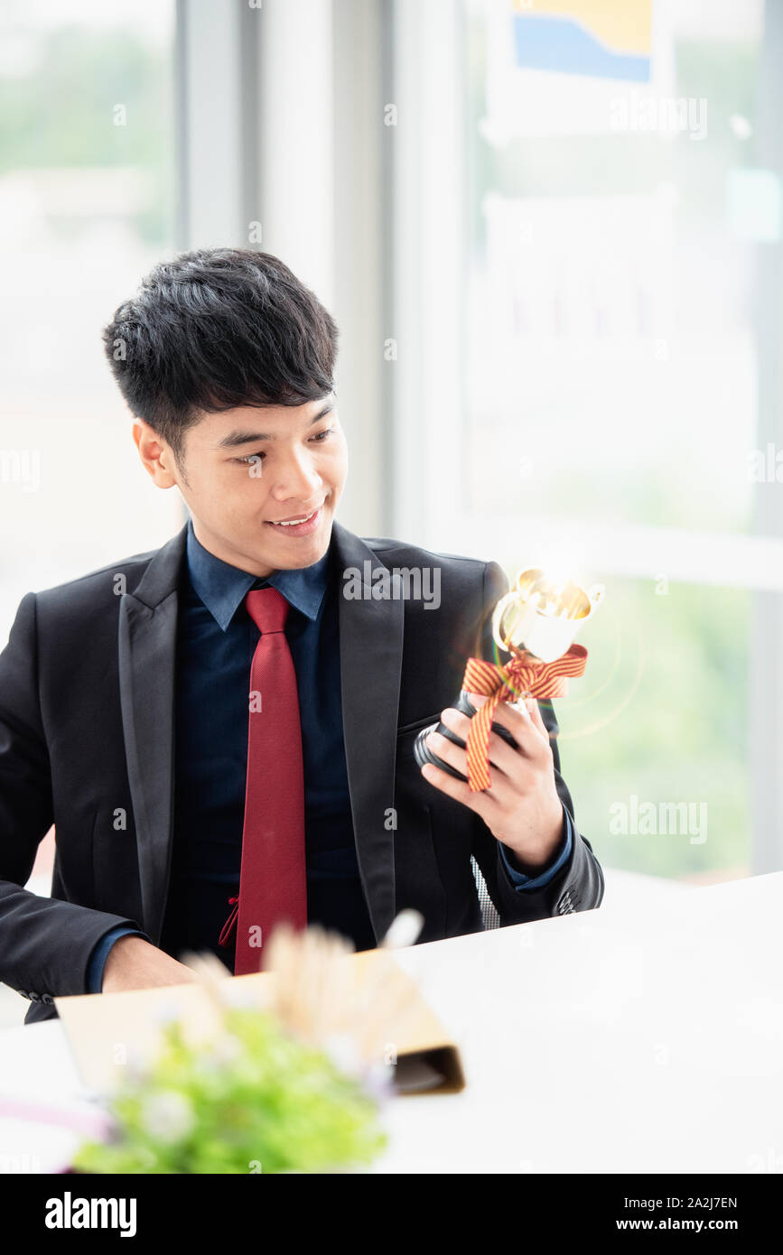 A young businessman with a confident suit sitting at a desk in a modern ...