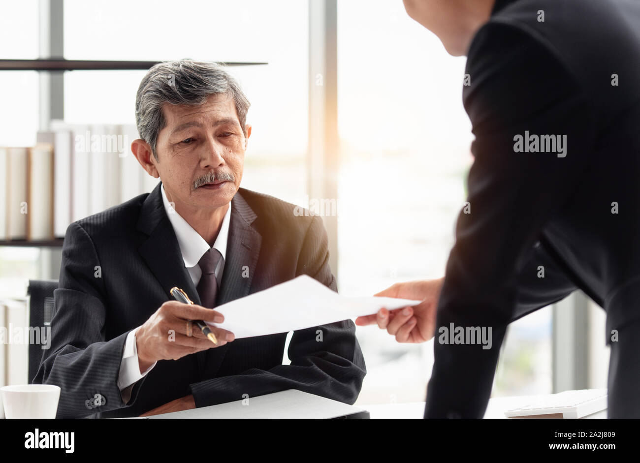 The young businessman sending the report to his boss on hand in the office room. Stock Photo