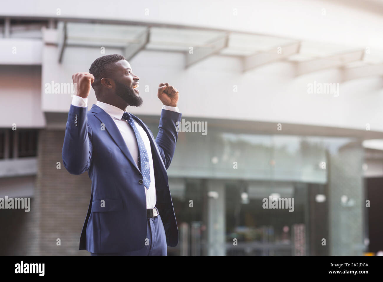 Happy black businessman celebrate victory with fists raised in air ...