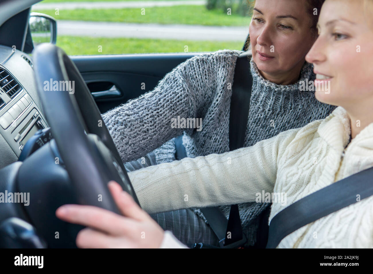 female driving instructor conducts a practical lesson with a female student Stock Photo