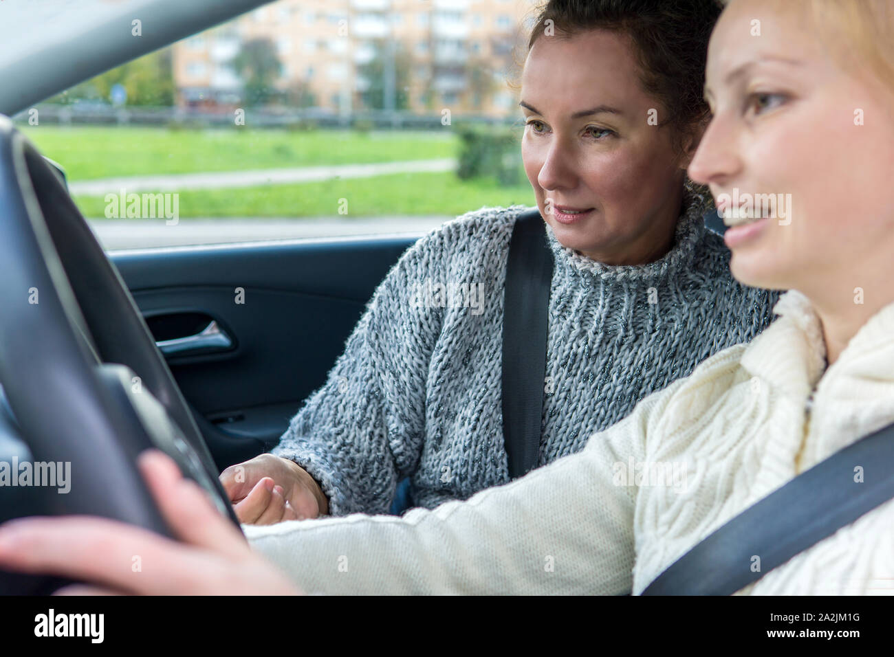female driving instructor conducts a practical lesson with a female student Stock Photo