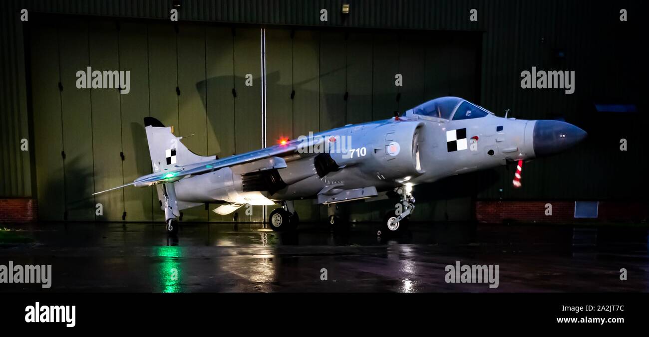 British aerospace Sea Harrier FA/2 built as FRS1 of 899 NAS stands outside a hangar at night lit up Stock Photo