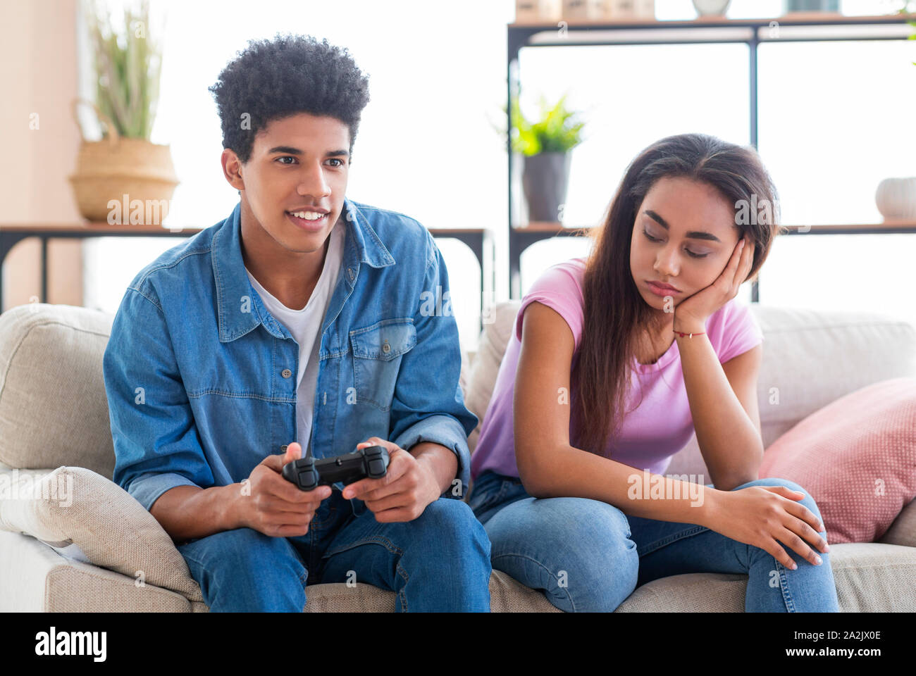 Couple Crisis. Guy Playing Videogames, Not Paying Attention To Girlfriend Stock Photo
