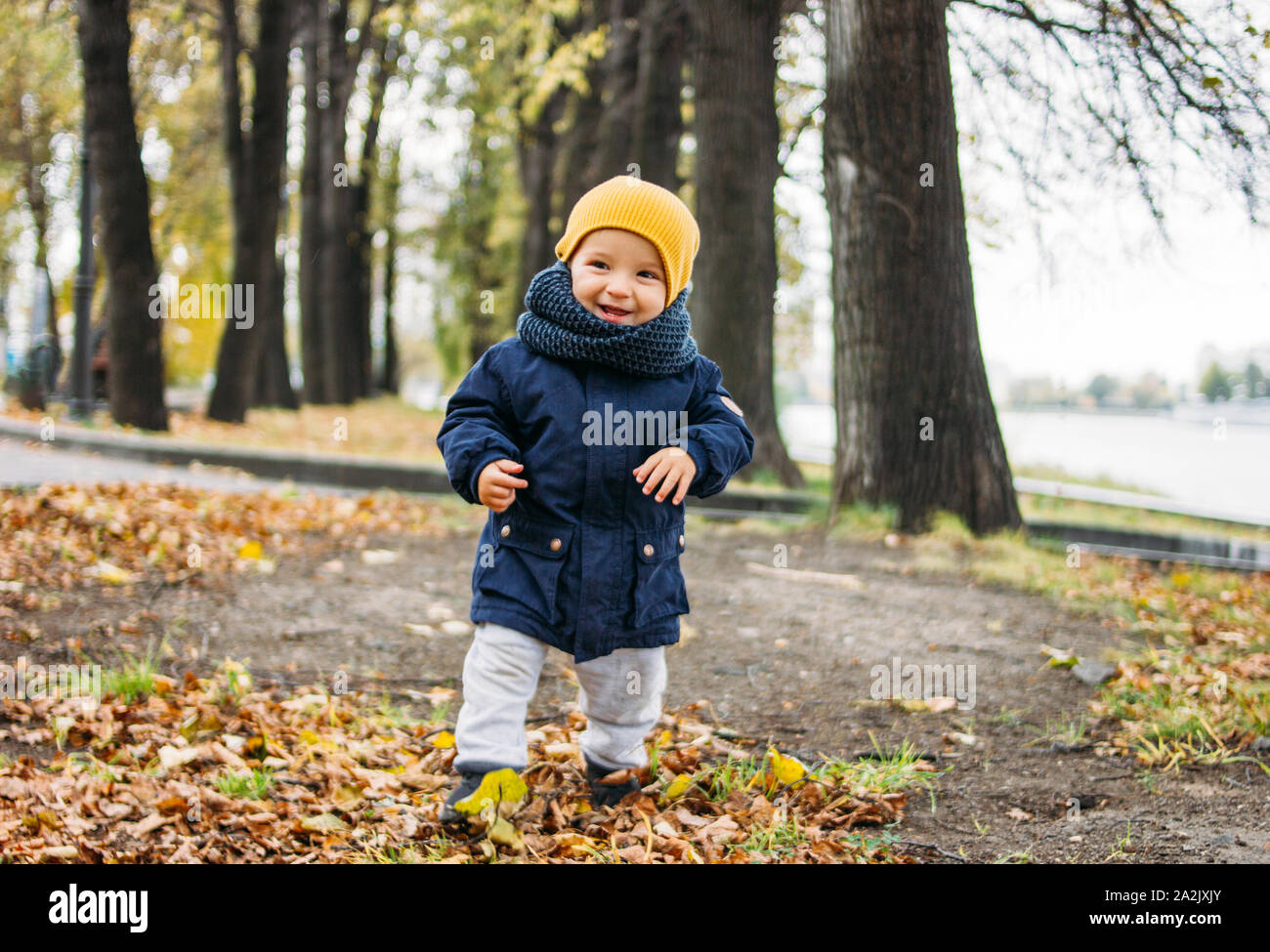 Cute happy baby boy in fashionable casual clothes in the autumn nature park Stock Photo