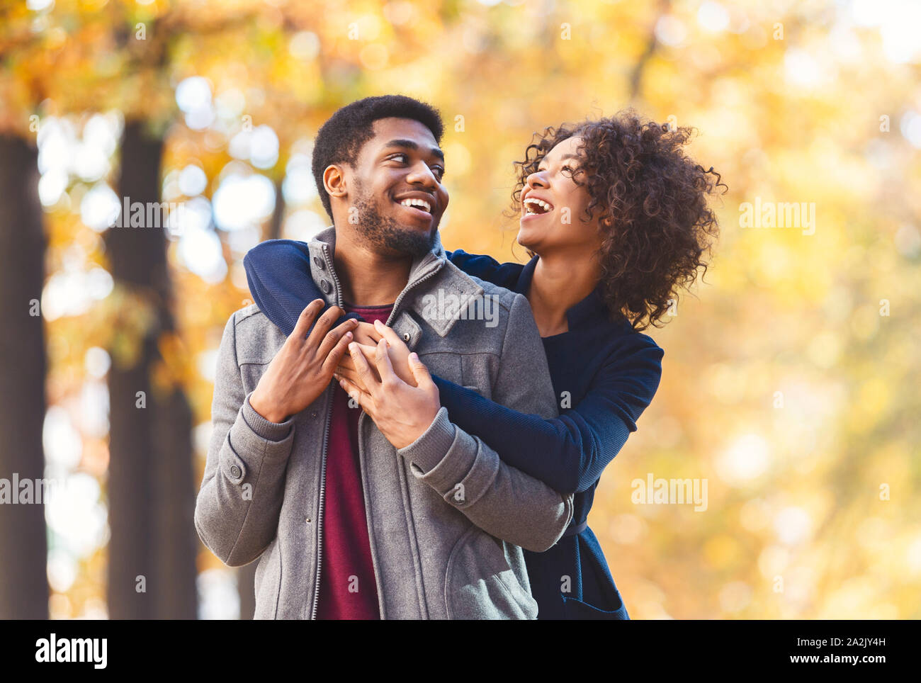 Portrait of sweet afro couple cuddling over autumn background Stock ...