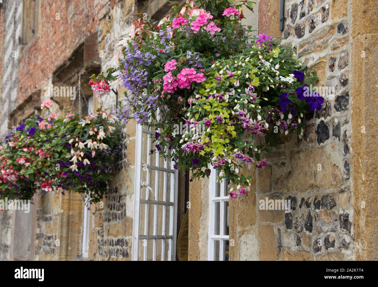 Pretty hanging baskets on cottage walls in Dorset Stock Photo - Alamy