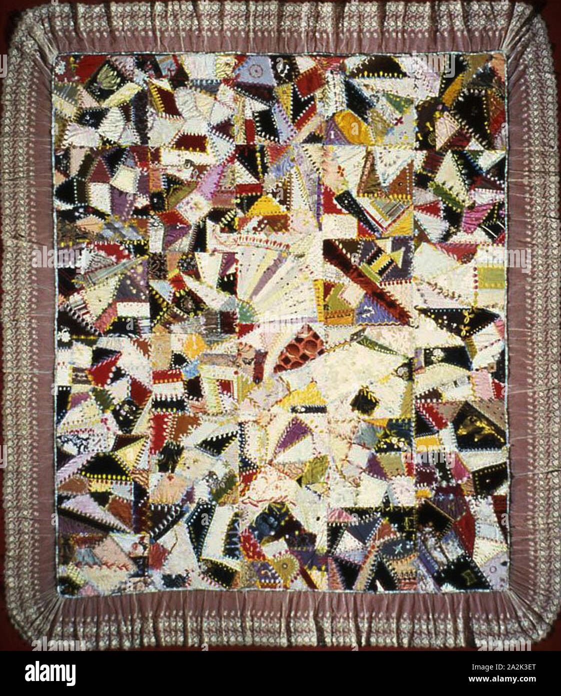 Bedcover (Crazy Quilt), 1880/85, United States, Silk, cotton, and wool, pieced plain, twill, and satin weaves, some with velvet, some with patterning and brocading wefts, and some self-patterned, some printed / painted, some watered (moiré), embroidered with silk, cotton, gilt-and-silvered-metal-strip-wrapped cotton and silk, and copper-metal-strip-wrapped wool in back, individual back, chain, detached chain, eyelet, feather, herringbone, overcast, satin, surface satin, single, stem stitches, laid work and couching, embellished and appliquéd with gilt and silver metal and gelatin paillettes Stock Photo