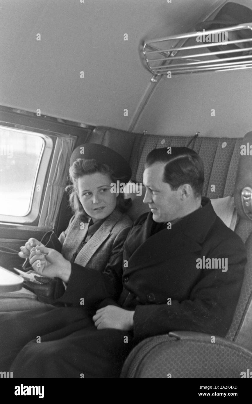 Ein Mann und eine Frau sitzen im Flugzeug und starten vom Flugplatz Tempelhof in Berlin, Deutschland 1930er Jahre. A man and a woman sitting in a plane, ready for taking off from Berlin Tempelhof airport, Germany 1930s. Stock Photo