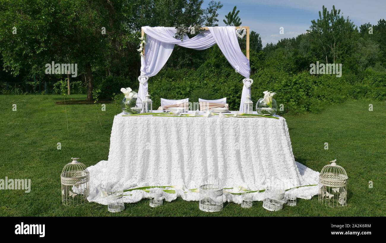 White Decoration Of The Wedding Arch And Table Covered With White Decoration For The Wedding Ceremony In The Green Garden Stock Photo Alamy