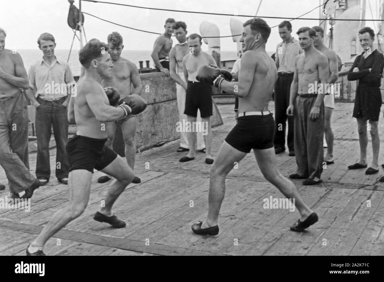 Die Männer der Besatzung des Walfangfabrikschiffs 'Jan Wellem' halten sich durch Boxen fit, 1930er Jahre. Crew members of the factory vessel 'Jan Wellem' doing a sparring, 1930s. Stock Photo