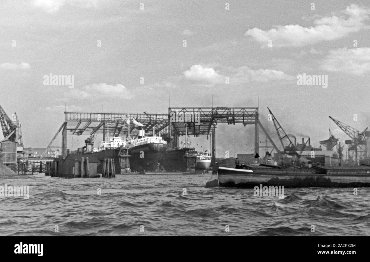Reges Treiben und auf den Werften im Hafen von Hamburg, Deutschland 1930er Jahre. Busy day at the wharfs and the port of Hamburg, Germany 1930s. Stock Photo
