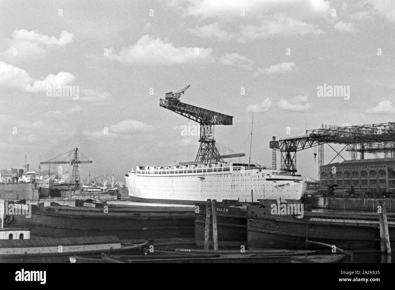 Ein neues weißes Passagierschiff wird auf einer Werft in Hamburg gebaut, Deutschland 1930er Jahre. A new white passenger vessel being built at a wharf at Hamburg, Germany 1930s. Stock Photo