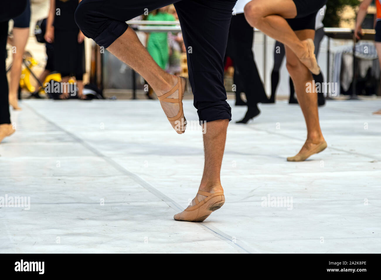 Ballet dancers practicing performance outdoors. Close up of ballerina feet wearing slippers practice moves in ballet class outside Stock Photo