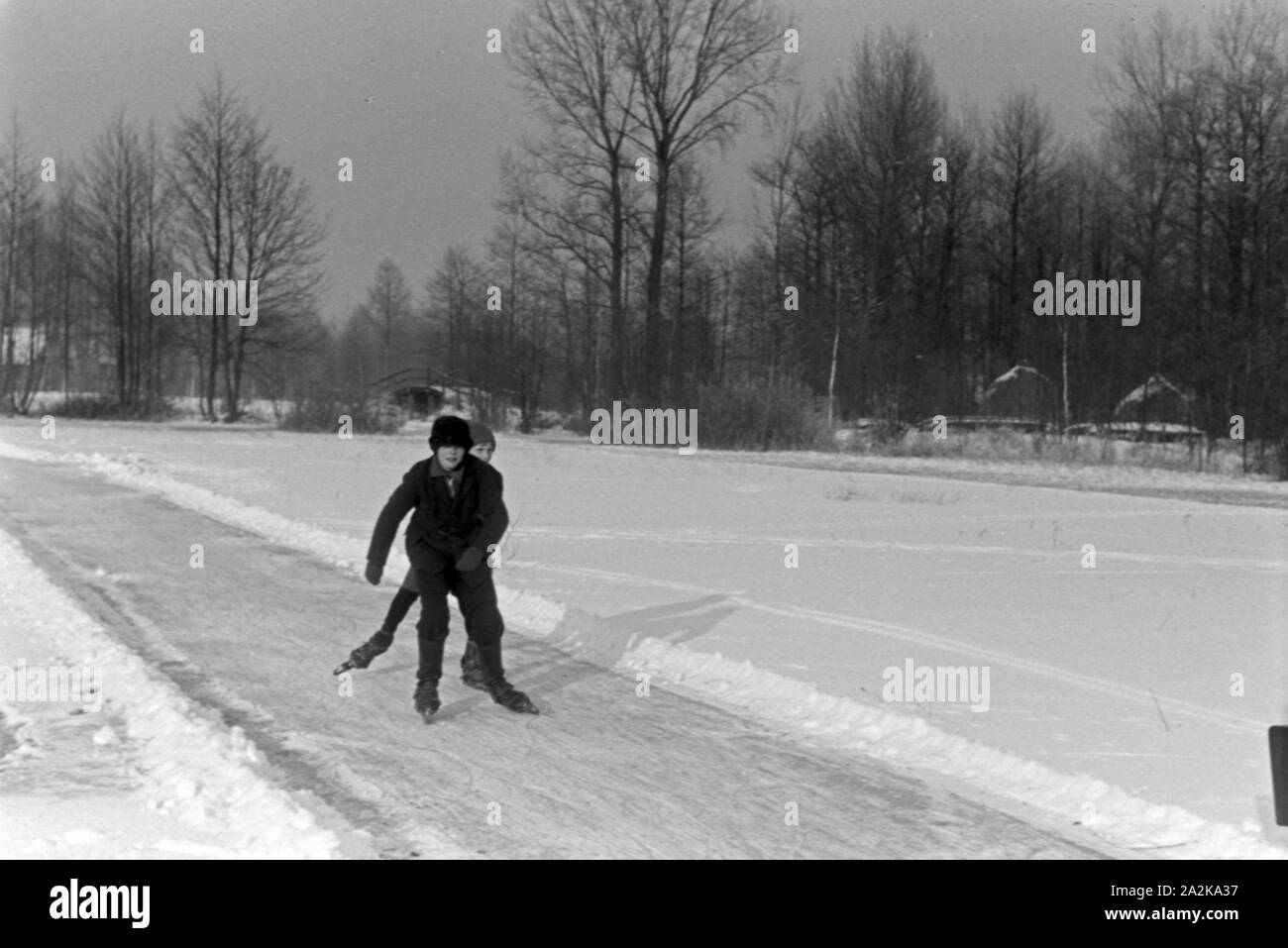 Zwei Jungen beim Eislaufen auf einem zugefrorenen See im Spreewald