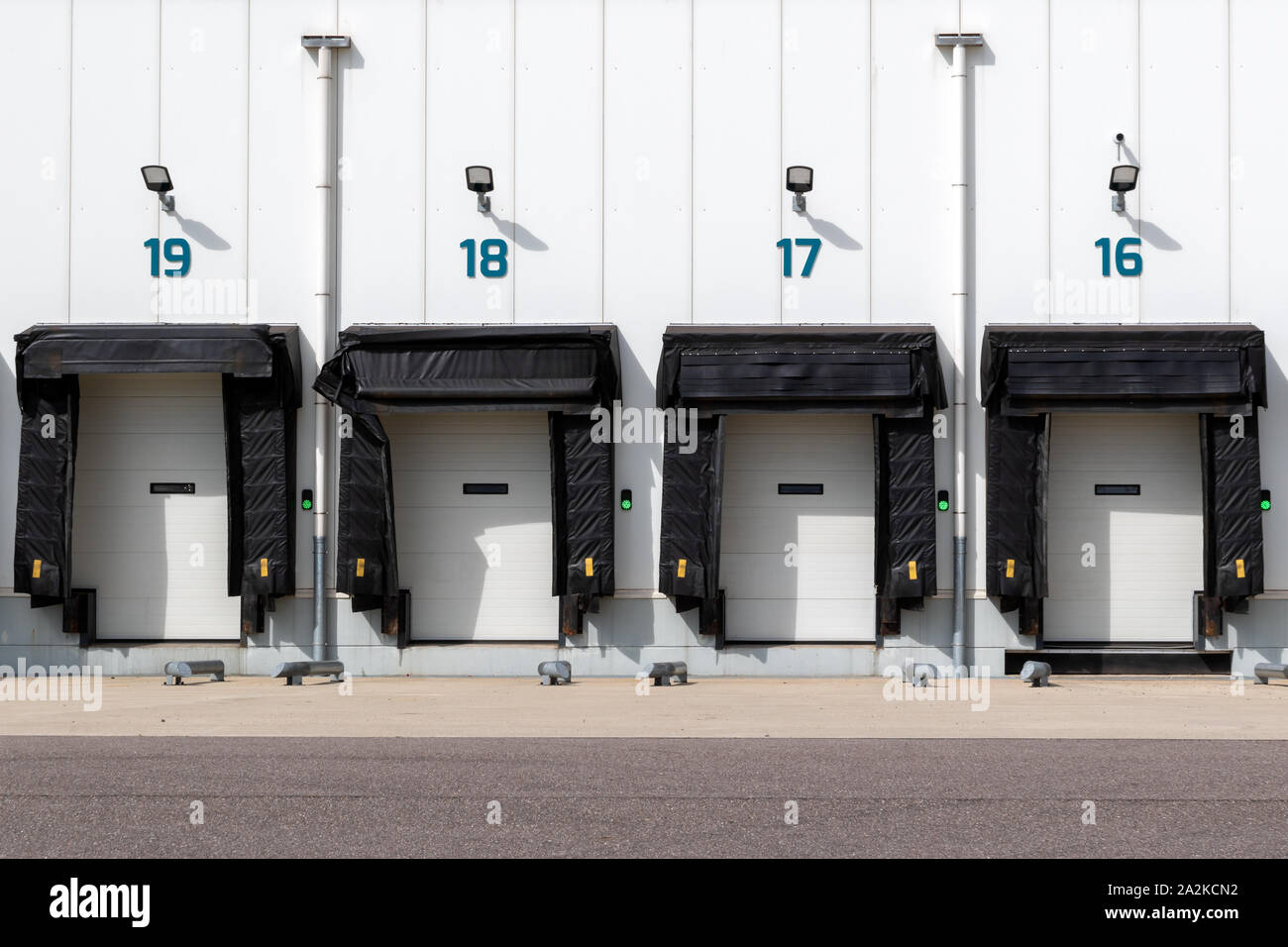 Row of loading docks with shutter doors at an industrial warehouse. Stock Photo