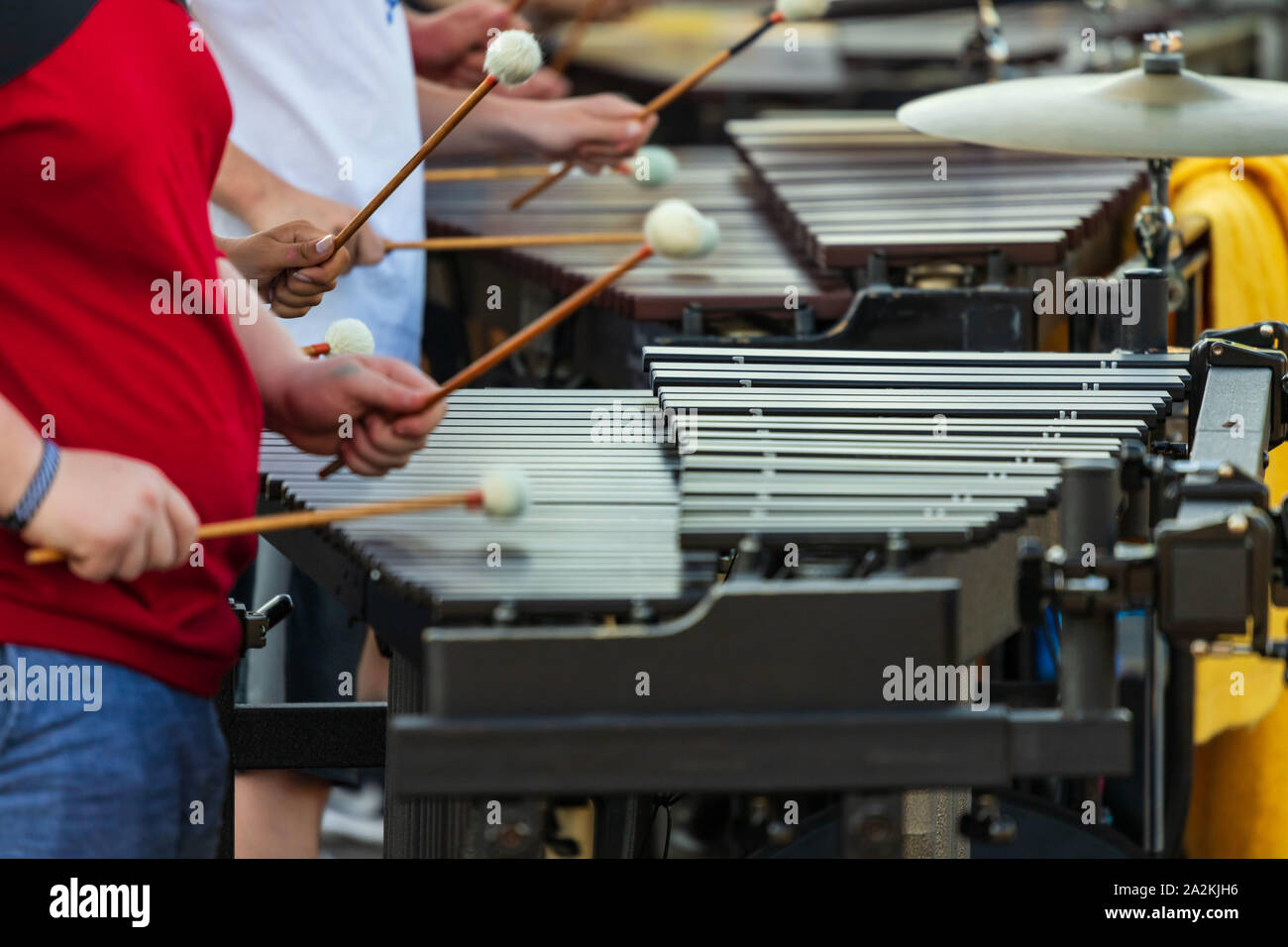 the flashing mallets of the sideline percussionists at rehearsal Stock Photo