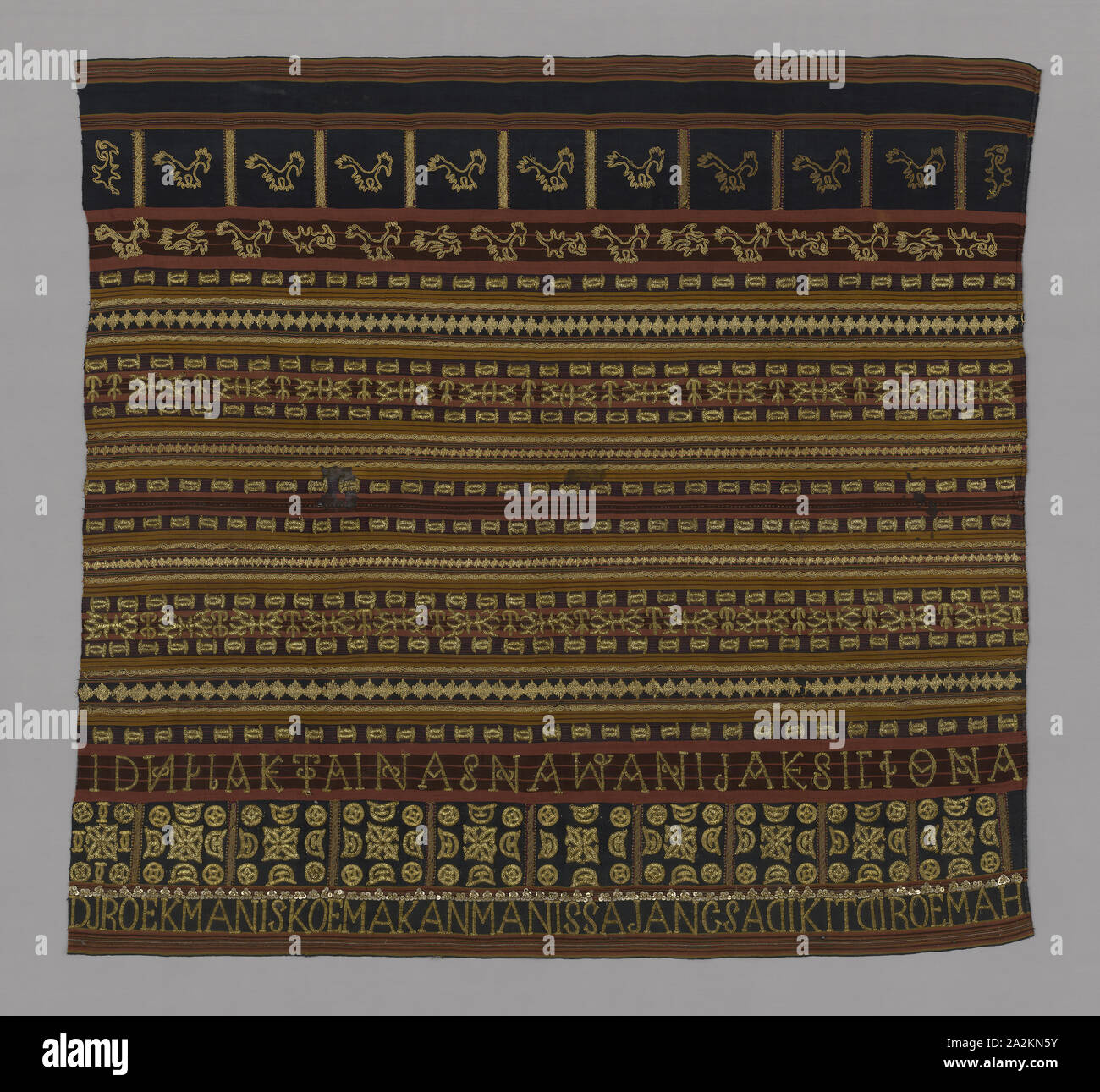 Woman’s Ceremonial Skirt (Tapis), 19th century, Abung, Indonesia, South Sumatra, Lampung, Indonesia, Two panels joined: cotton and silk, warp-faced, weft ribbed plain weave, embroidered with silk, gold-leaf-over-lacquered-paper strip wrapped cotton, cotton, gilt-metal coils, gilt-metal wire wrapped cotton, gilt-metal-strip wrapped cotton and gilt-metal spangles in running stitches, laidwork, couching, and padded couching, 114.5 x 122 cm (45 x 48 in Stock Photo
