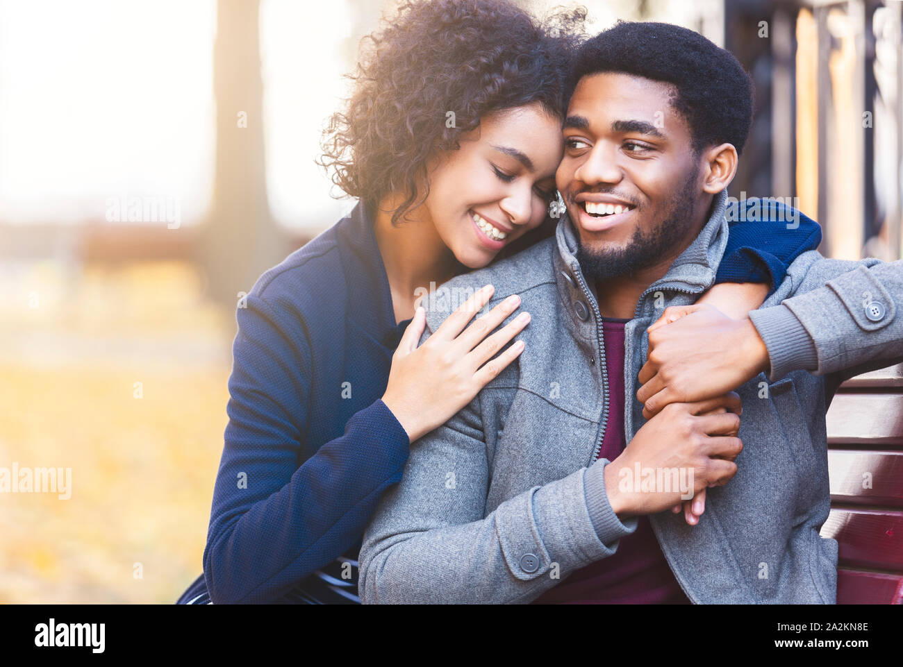 Curly black girl hugging her man with big love Stock Photo - Alamy