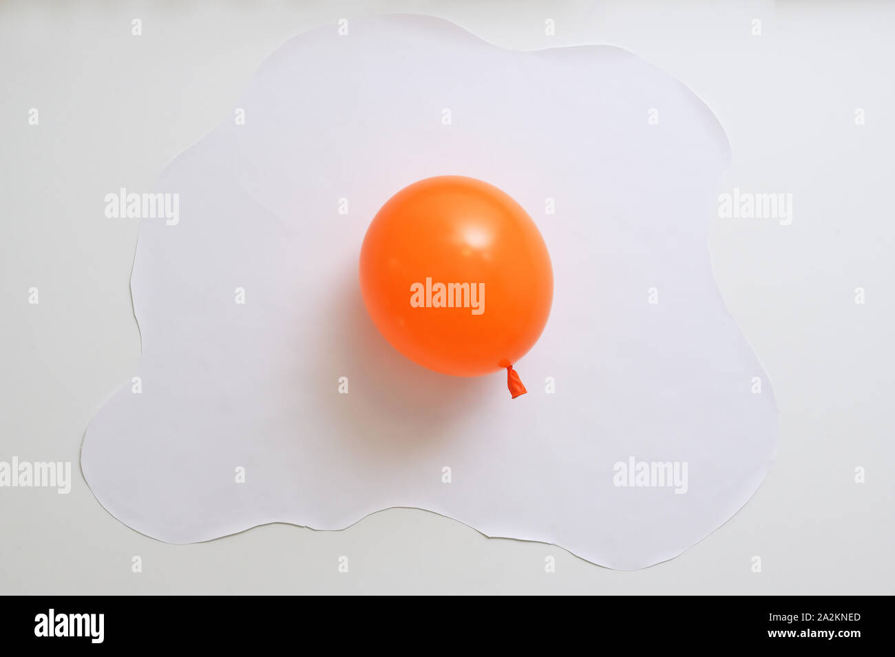 Abstract Orange Balloon With White Paper In Shape Of An Fried Egg Stock Photo