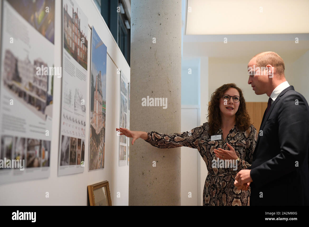 The Duke of Cambridge looks at artwork illustrating the development of the new building with one of the architects at the official opening of Keble College's new graduate building in Oxford. Stock Photo