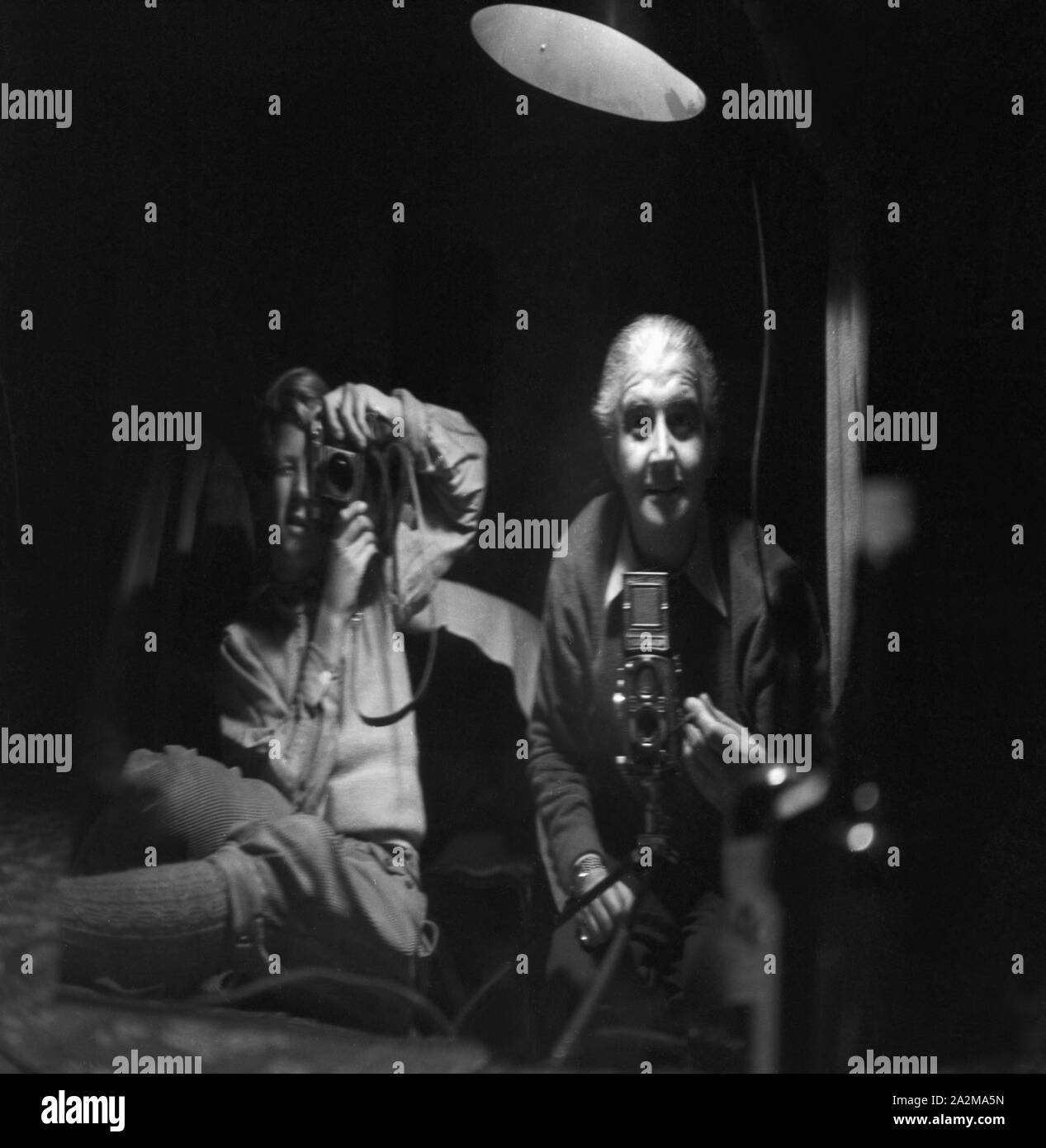 Zwei Fotografen fotografieren sich selbst, einer mit einer Kleinbildkamera, der andere mit der Rolleiflex für Mittelformat, Deutschland 1940. Two photographers taking a picture of themselves, Germany 1940. Stock Photo