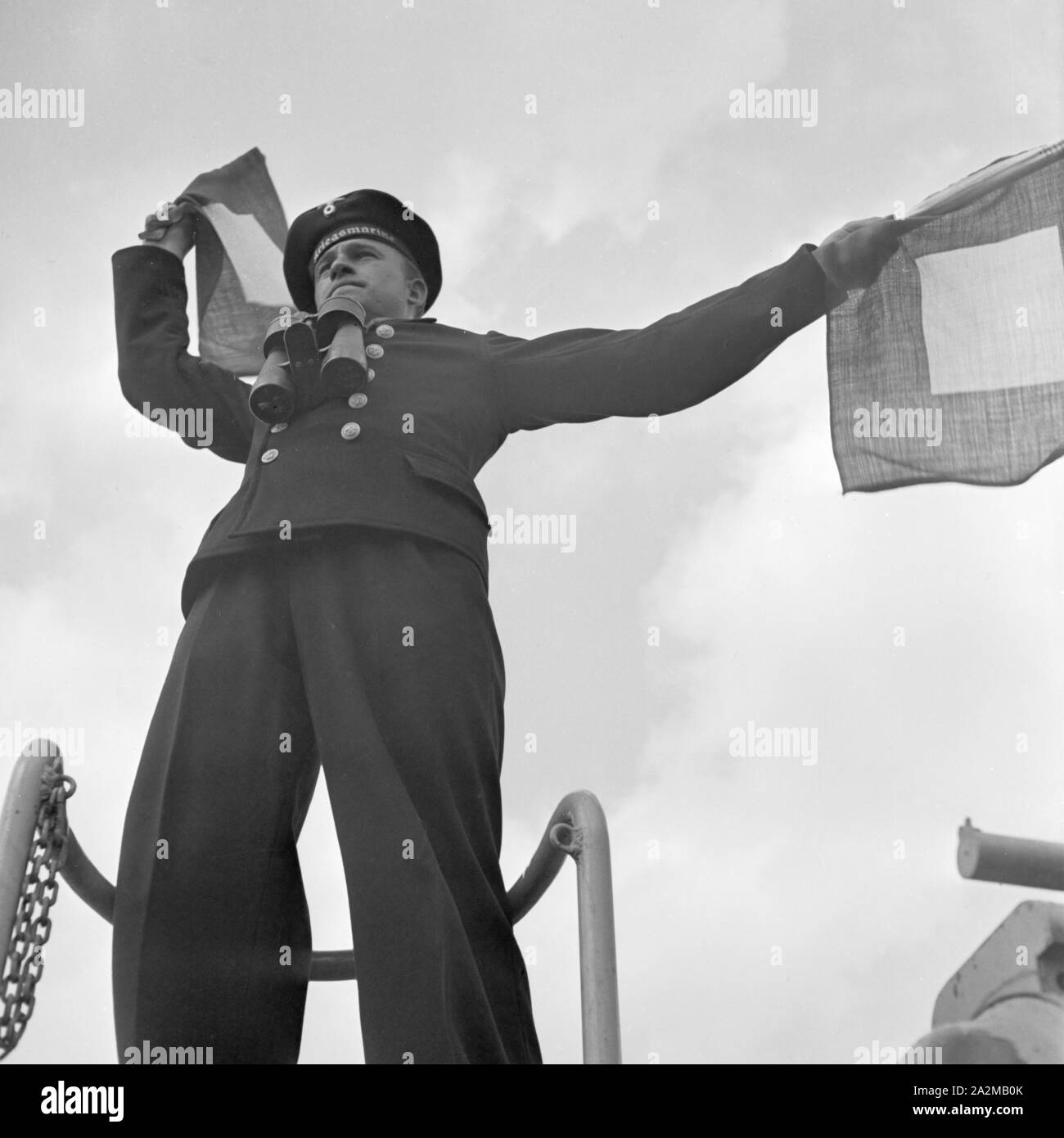 Original-Bildunterschrift: Dienst des Matrosen: Signalwinken an Bord eines Torpedoboots, Deutschland 1940er Jahre. Flag semaphore on deck of a torpedo boat, Germany 1940s. Stock Photo