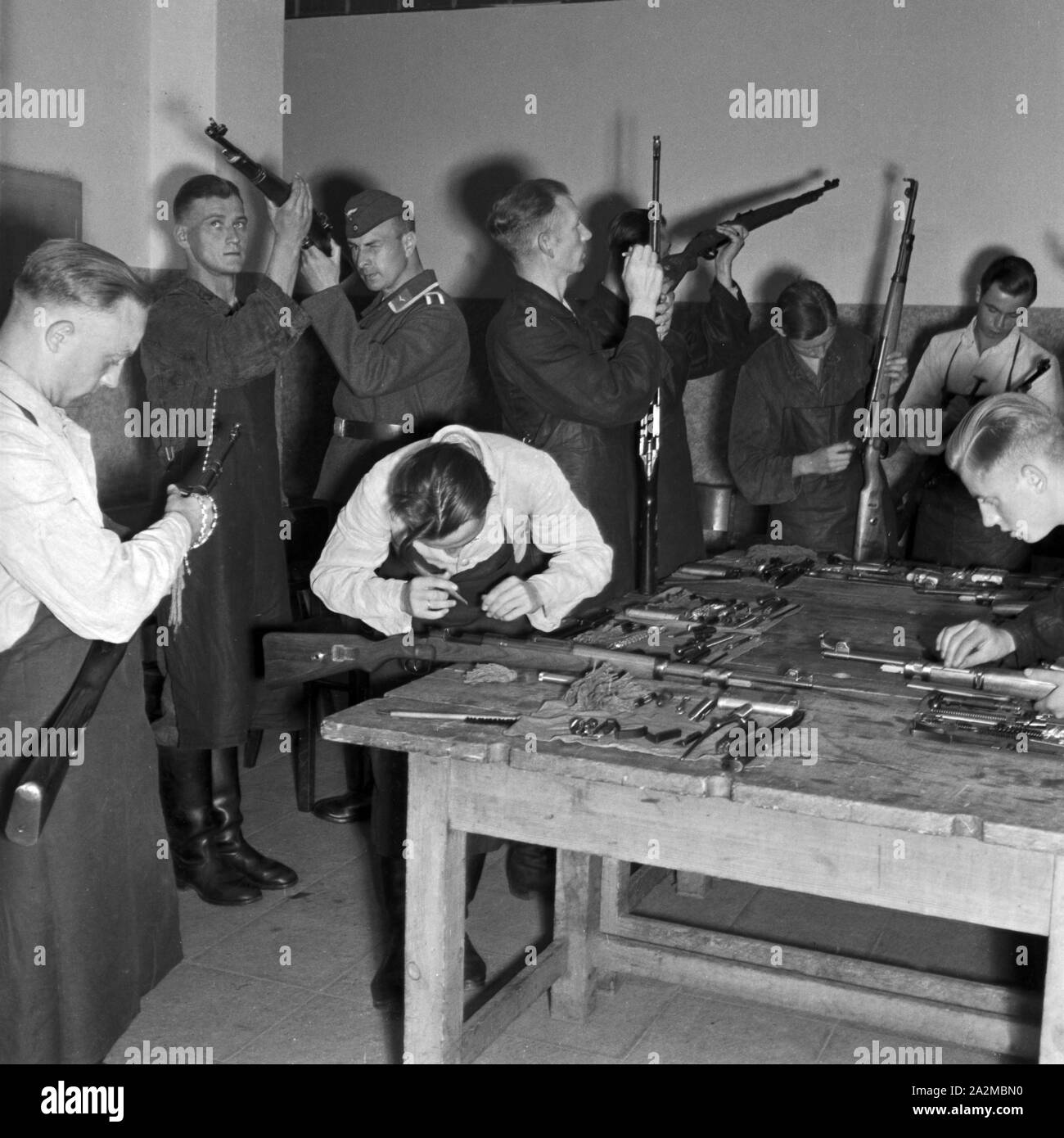 Original-Bildunterschrift: Dienst des Soldaten: Waffenreinigen, Deutschland 1940er Jahre. Soldier's duty: cleaning the weapons, Germany 1940s. Stock Photo