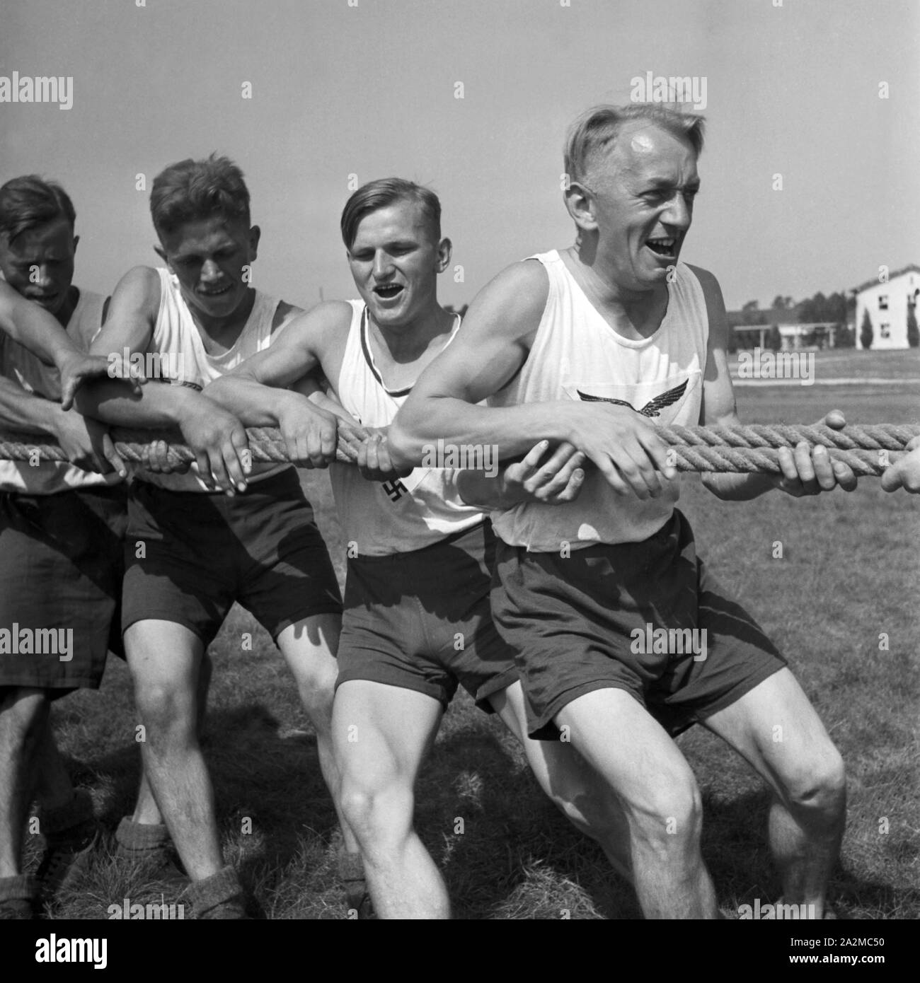 Original-Unterschrift: Tauziehen bei den Soldaten: beide Gruppen liegen am Boden und warten auf den Befehl 'Los!', Deutschland 1940er Jahre. Soldier's tug-of-war: both parties lying on the floor and wait for the command 'Go!', Germany 1940s. Stock Photo