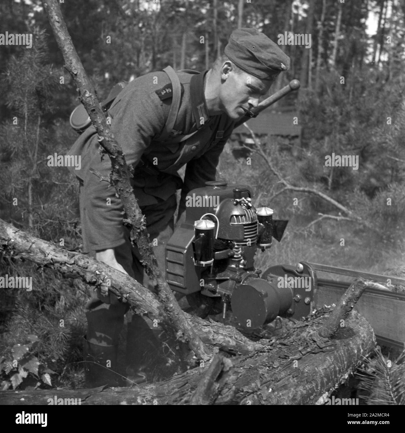 Original-Bildunterschrift: Bei der Arbeit mit der Kraftsäge, Deutschland 1940er Jahre. Soldier using a chainsaw, Germany 1940s. Stock Photo