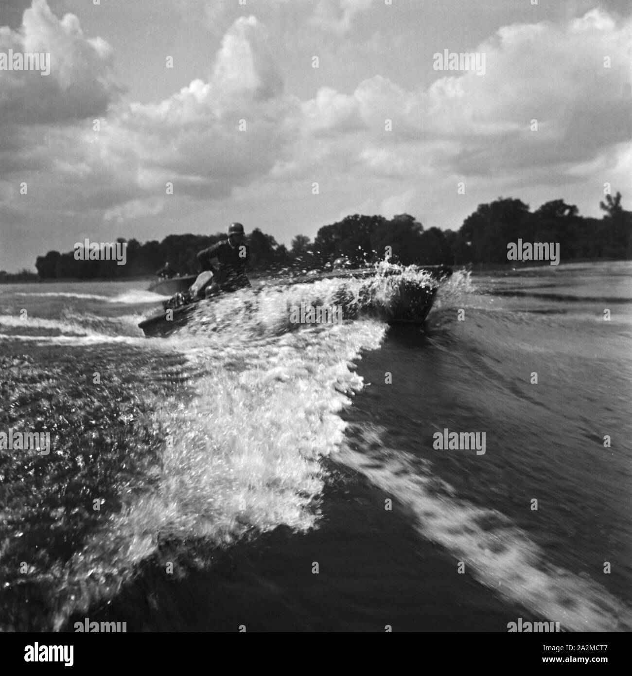 Original- Bildunterschrift: Sturmboot überquert in höchster Geschwindigkeit einen Fluß, Deutschland 1940er Jahre. Assault boat crossing a river with high speed, Germany 1940s. Stock Photo