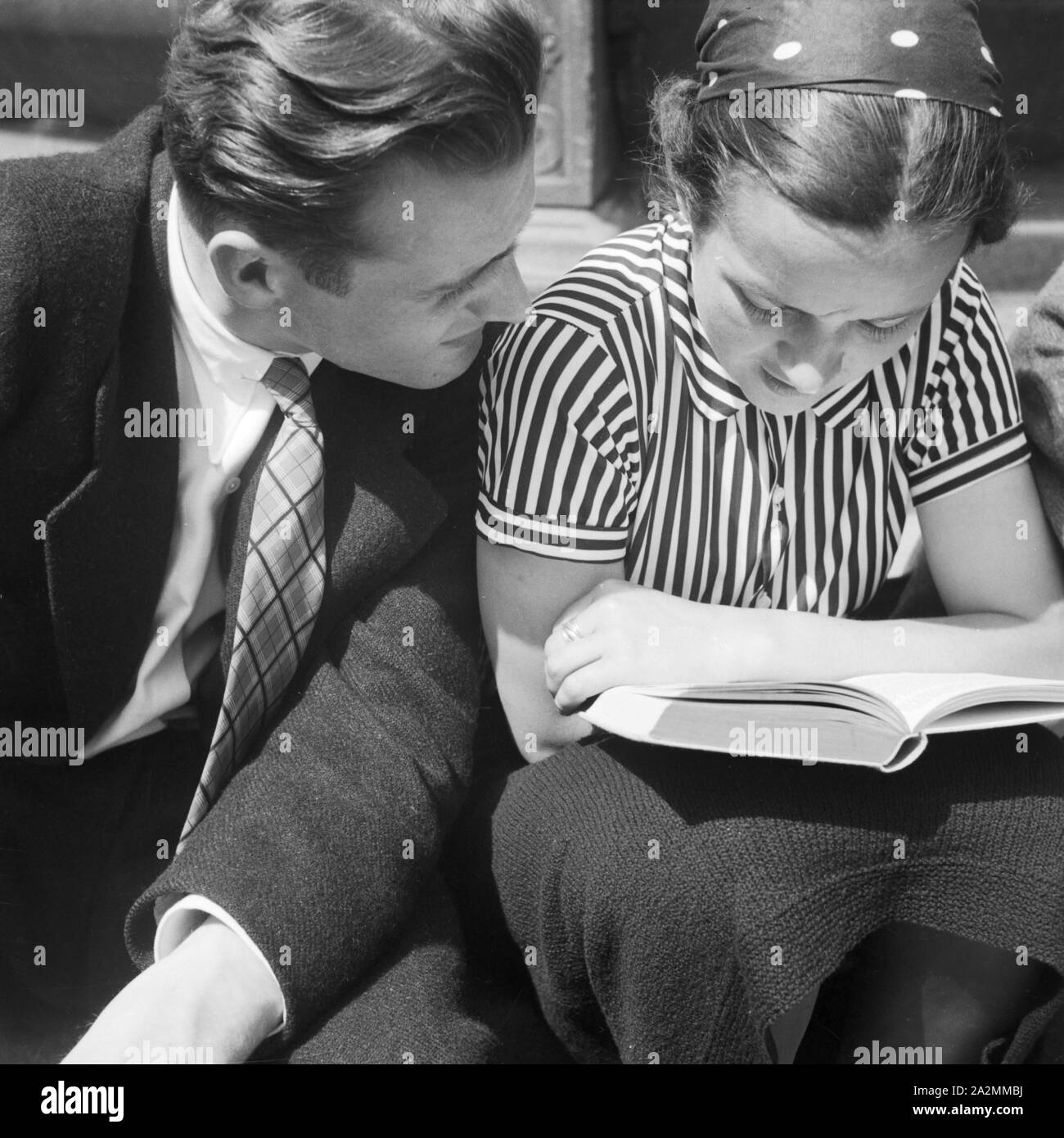 Ein Mann und eine Frau lesen ein Buch, Deutschland 1930er Jahre. A man and a woman reading a book, Germany 1930s. Stock Photo