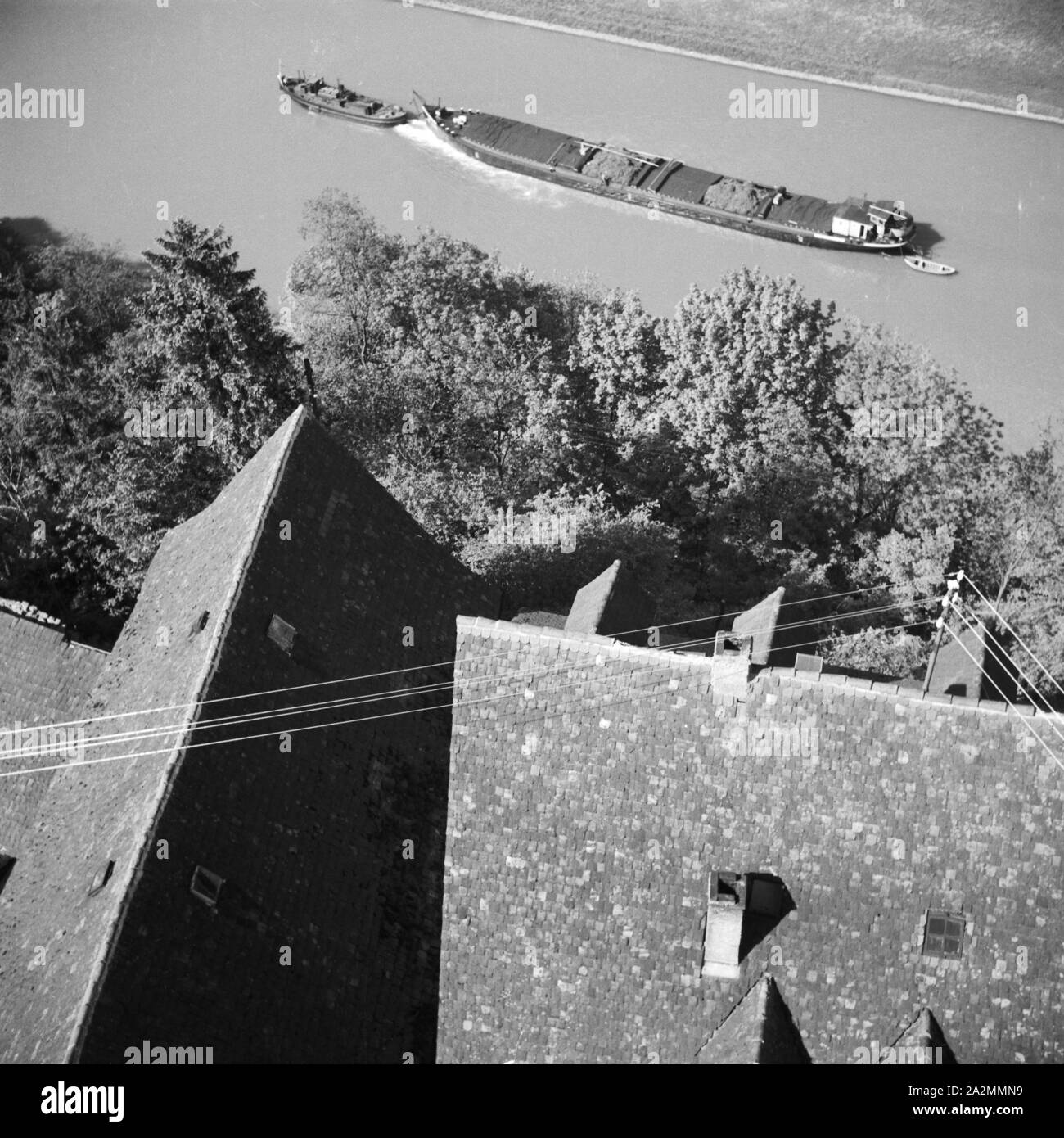 Ein Schlepper zieht auf dem Neckar an Bad Wimpfen vorbei, Germany 1930s. A freight ship on river Neckar passing the town of Bad Wimpfen, Germany 1930s. Stock Photo