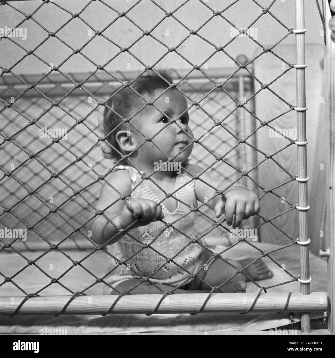 Kleines Kind in seinem Laufstall, Deutschland 1930er Jahre. Little toddler in his playpen, Germany 1930s. Stock Photo