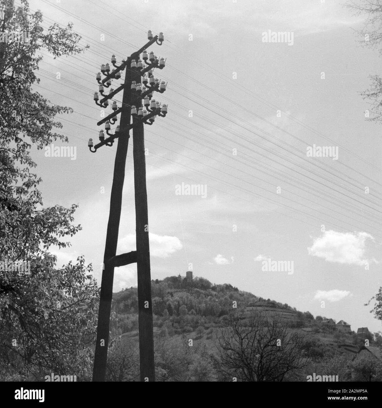 Strommast mit Telegraphenleitung, Deutschland 1930er Jahre. Telegraph wires, Germany 1930s. Stock Photo