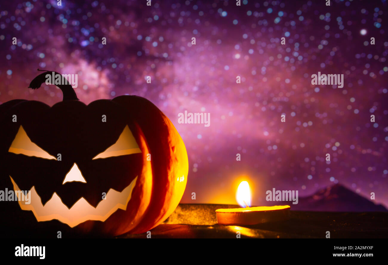 Spooky pumpkin head jack o' lantern glowing with a burning candle in ...